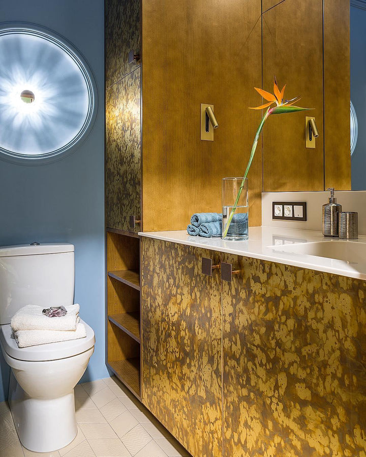 Salle de bain aux meubles dorés patinés, deux petites appliques orientables fixées au mur 10