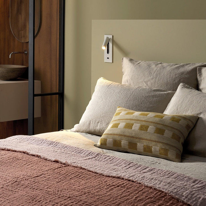Applique blanche avec prise USB au-dessus d'un lit aux draps de lin beige 31