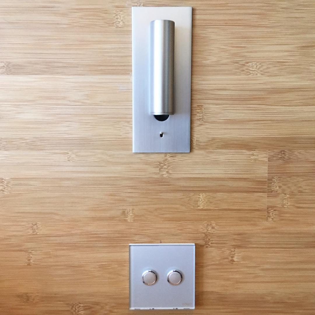 Applique argentée sur un mur en bambou, spot orienté vers le bas, interrupteur tactile en dessous 34