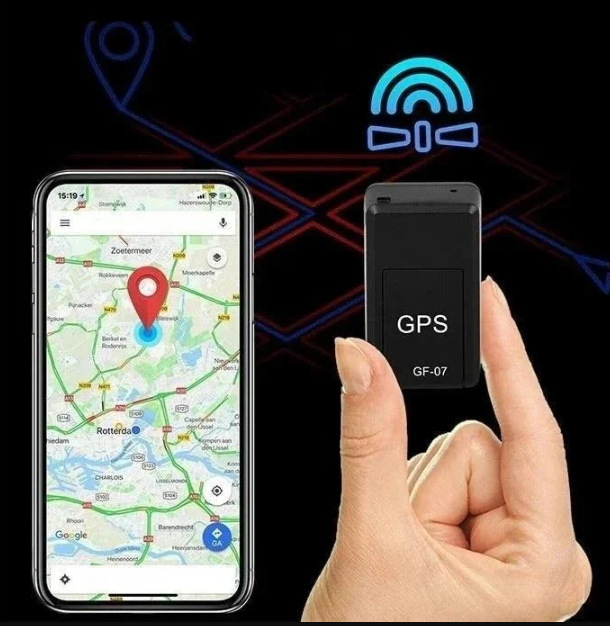 Boîtier noir tenu entre deux doigts, à côté d'un smartphone montrant une carte avec un repère rouge, sur fond sombre. 2