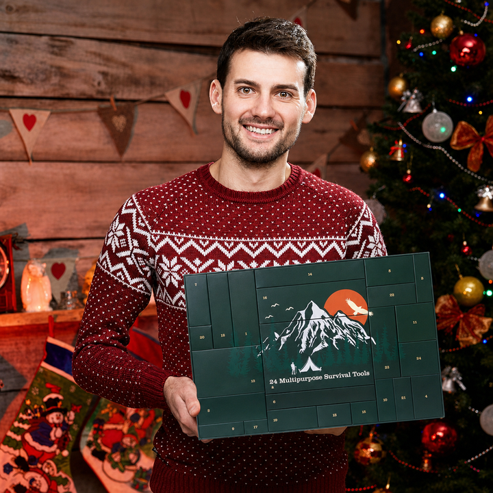 Homme souriant en pull de Noël rouge tenant le calendrier vert devant un sapin décoré 9
