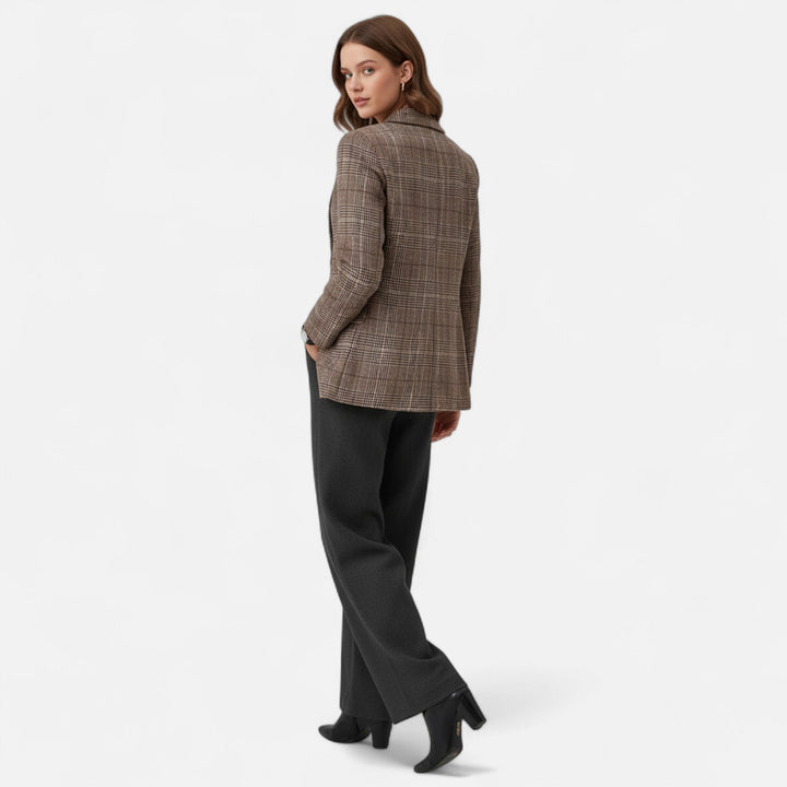 Mannequin vue de dos et en pied, tournant la tête, portant le blazer à carreaux avec un pantalon gris foncé et des bottines. 3