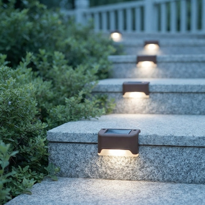 Lampes solaires marron posées sur des marches en granit bordées d'arbustes, éclairant chaque marche d'une lumière blanc chaud. 2