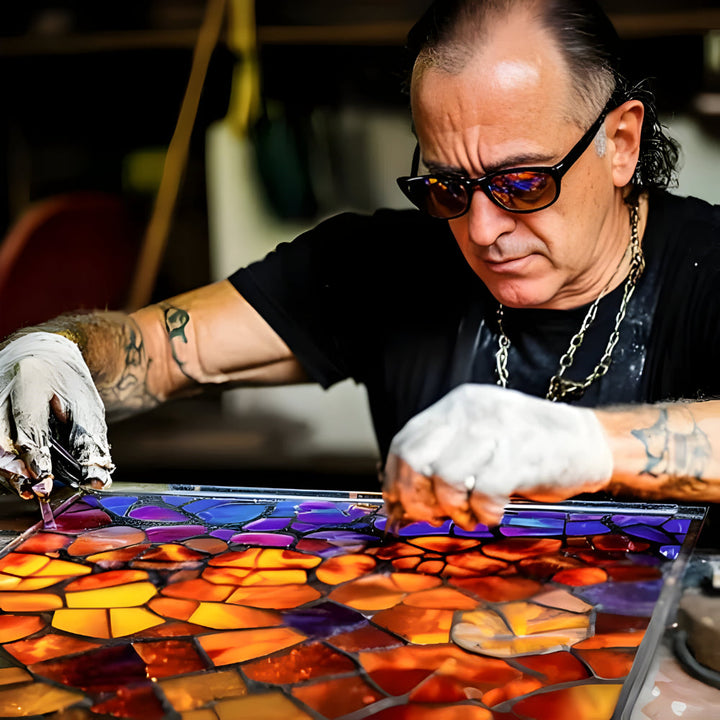 Artisan tatoué aux lunettes de soleil assemblant à la main des morceaux de verre coloré 5