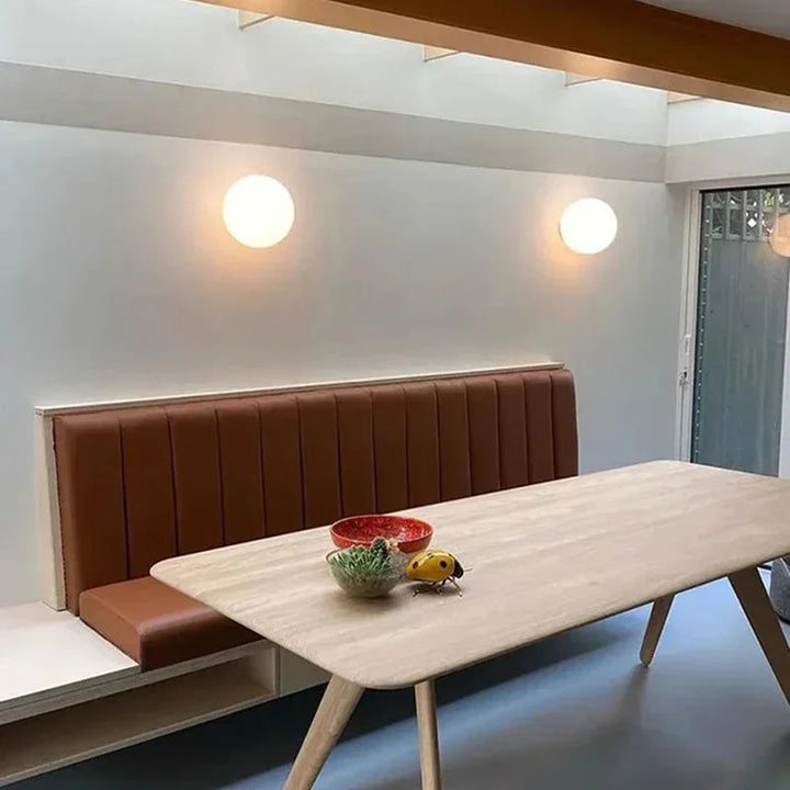 Deux sphères murales allumées au-dessus d'une banquette en cuir et d'une table en bois 12
