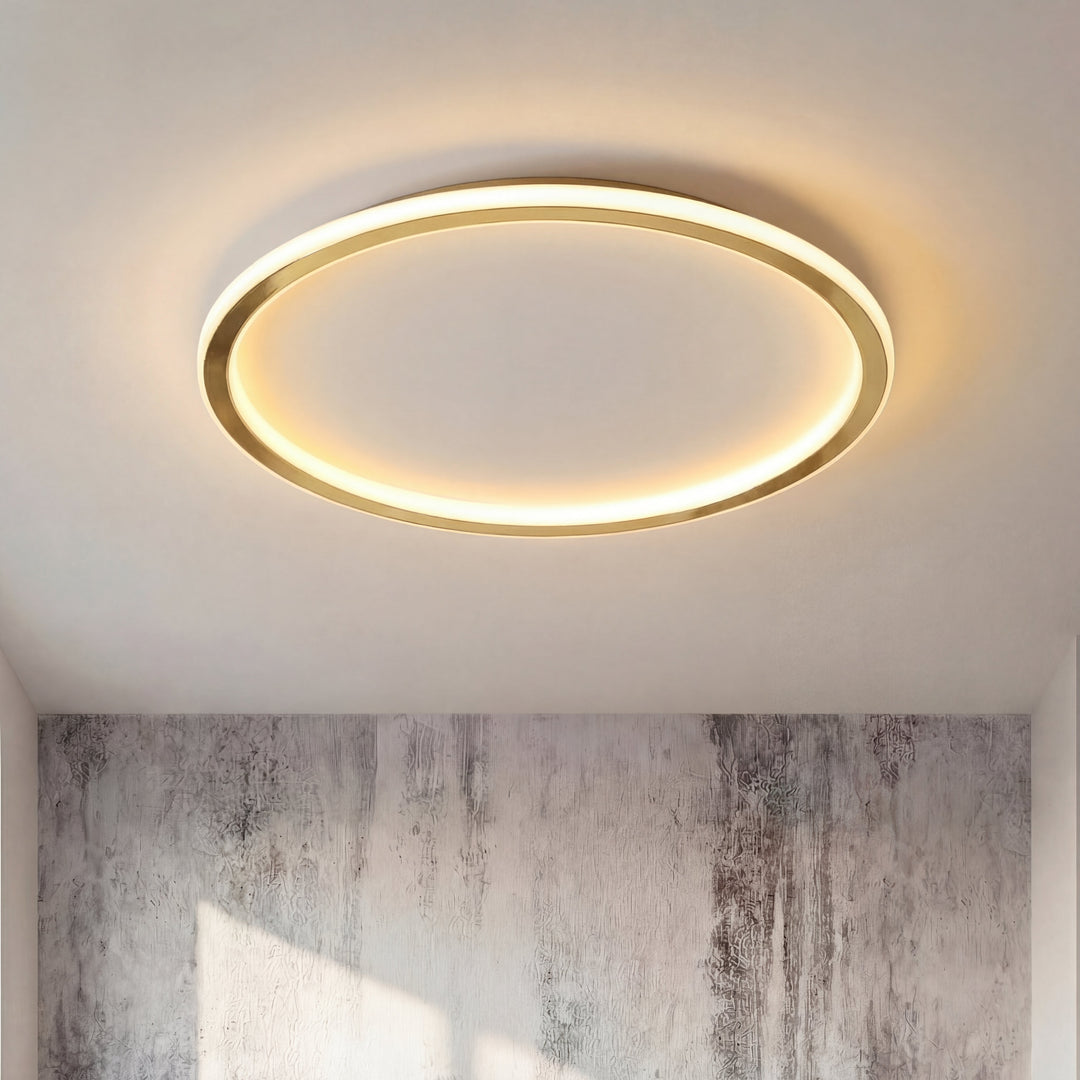 Plafonnier doré allumé en vue plongeante, au-dessus d'un mur gris à l'aspect béton texturé 7