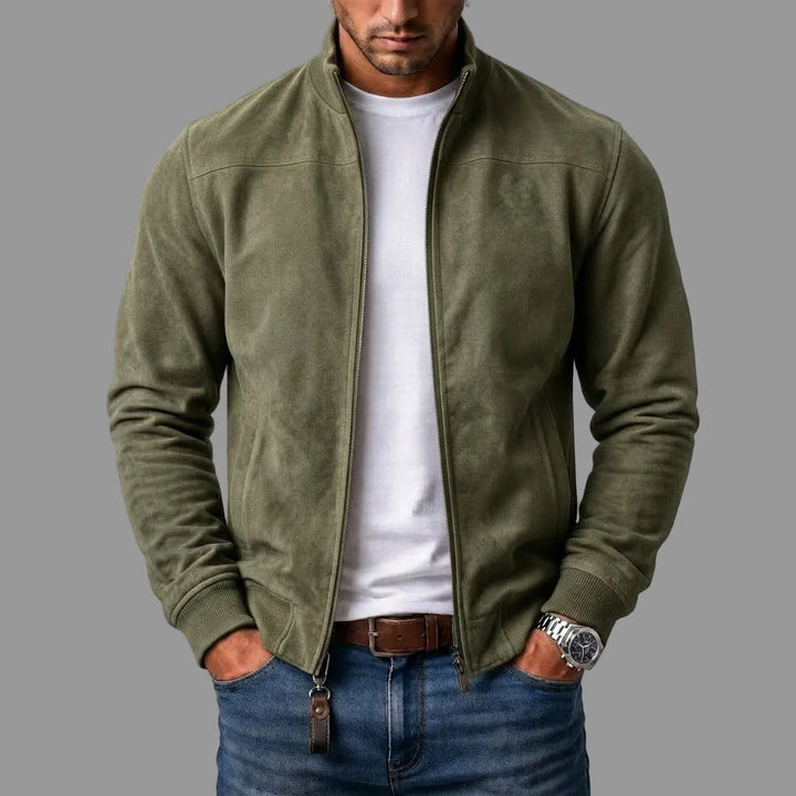Homme portant le blouson en daim vert kaki zippé ouvert sur un t-shirt blanc, avec jean et ceinture en cuir marron. 3
