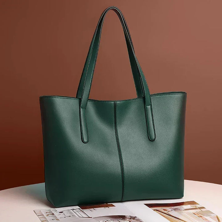Sac cabas vert foncé présenté sur une table devant un fond brun, avec un magazine ouvert 4
