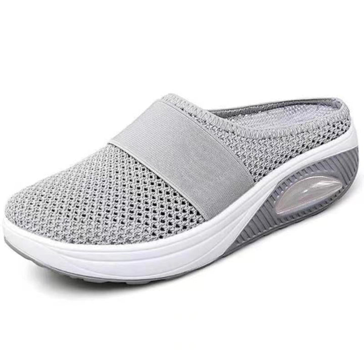 Mule gris clair en maille sur fond blanc, vue de trois quarts avec semelle blanche et coussin d'air 9