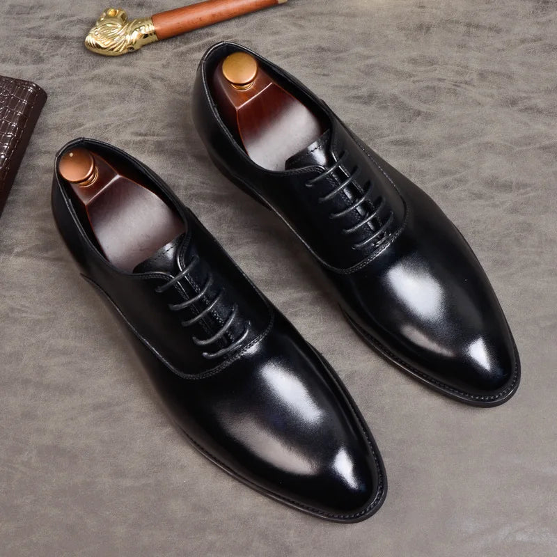 Paire d'Oxford noires en cuir verni vue du dessus avec embauchoirs, sur fond gris texturé 8