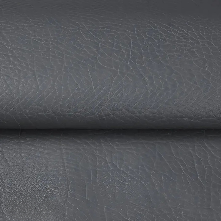 Gros plan sur la texture grainée du cuir synthétique gris foncé, légèrement plié 8