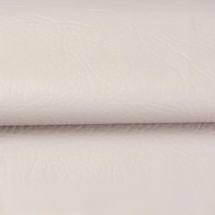 Gros plan sur la texture du cuir synthétique blanc cassé, plié au milieu 10