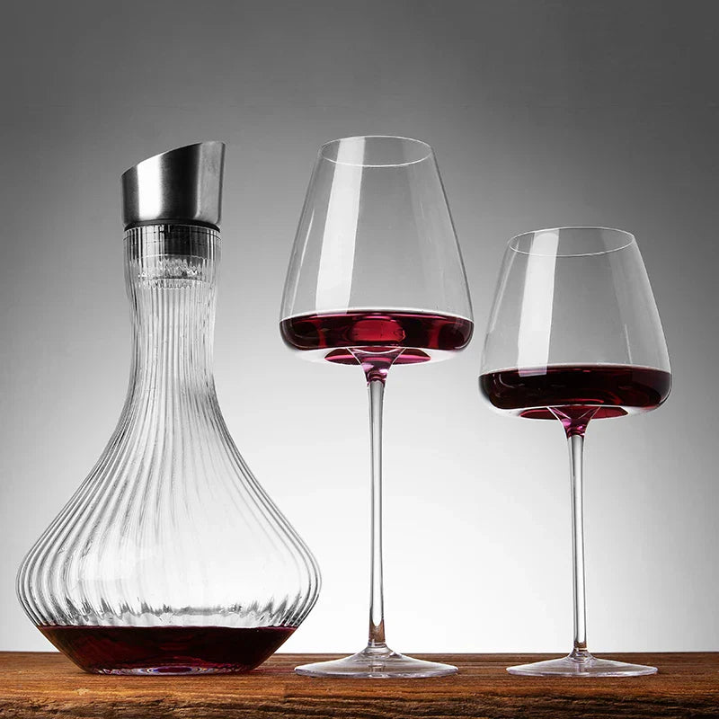 Carafe cannelée à bouchon métallique et deux verres de vin rouge sur une table en bois 4