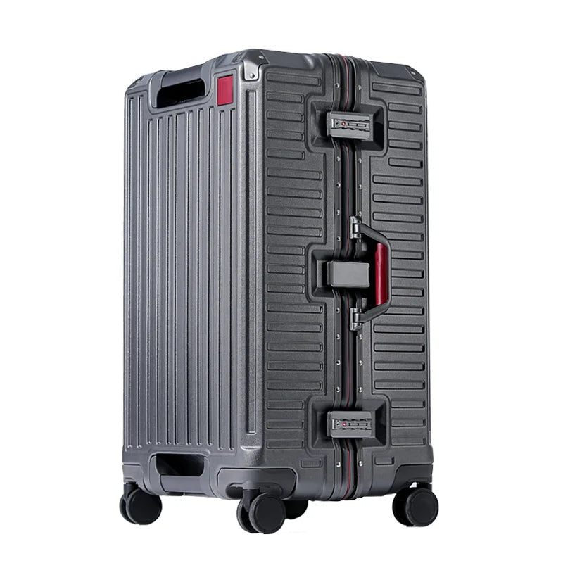 Valise rigide gris anthracite avec cadre en aluminium, poignée latérale à pans rouges, serrures à code et quatre roulettes pivotantes, vue de trois quarts. 1