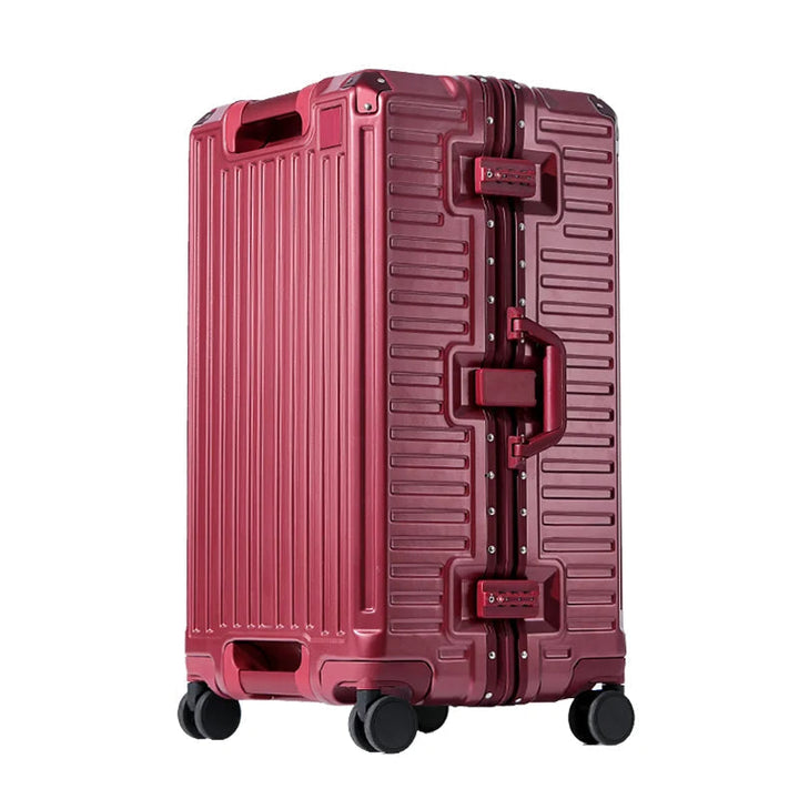Valise rigide rouge bordeaux à cadre aluminium, serrures à code et poignée latérale assortie, posée sur quatre roulettes pivotantes, vue de trois quarts. 9