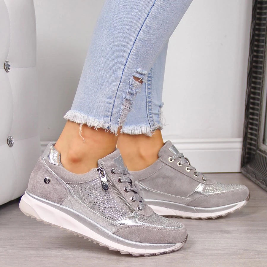 Version grise des baskets à lacets et zip latéral, portées avec un jean clair effiloché, vue de profil. 2