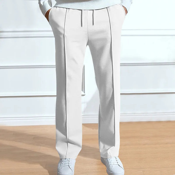 Pantalon blanc à cordon et plis verticaux, porté avec un haut clair et des baskets blanches. 4