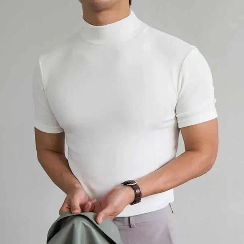 T-shirt blanc à col montant et manches courtes porté par un homme avec une montre au poignet, pantalon clair. 4