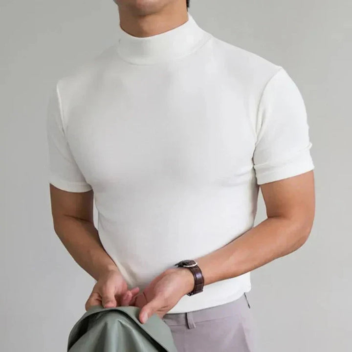T-shirt blanc à col montant et manches courtes porté par un homme avec une montre au poignet, pantalon clair. 4
