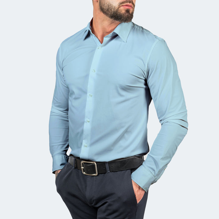 Chemise bleu clair boutonnée portée de face, mains dans les poches d'un pantalon bleu marine 12