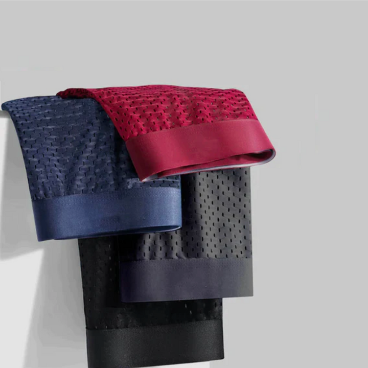 Boxers rouge, bleu, gris et noir en maille ajourée, pliés et suspendus les uns sur les autres 3