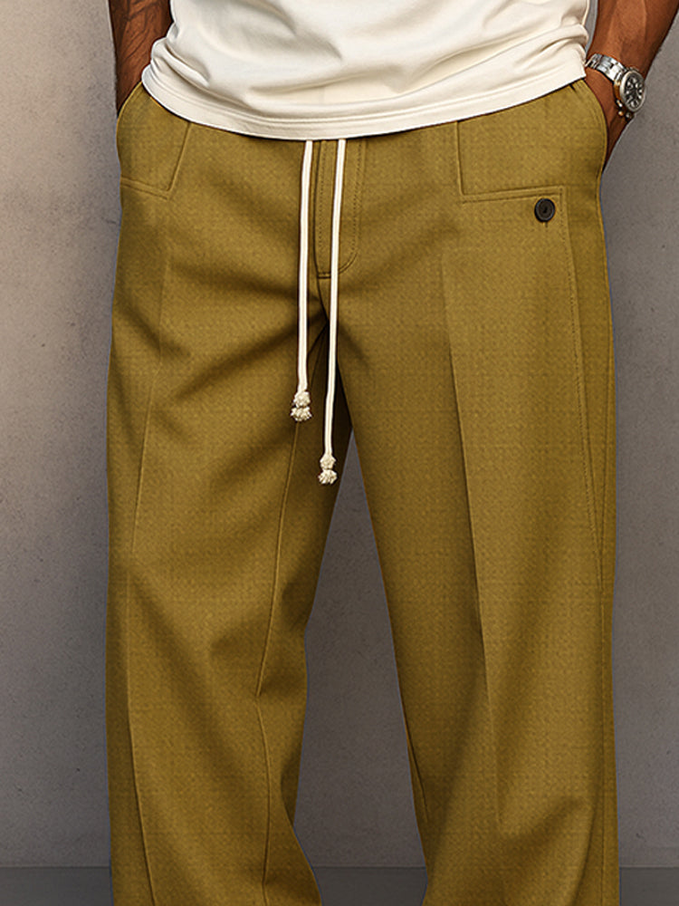 Gros plan sur la taille du pantalon vert olive : cordon blanc aux extrémités nouées, poches avant et bouton. 7