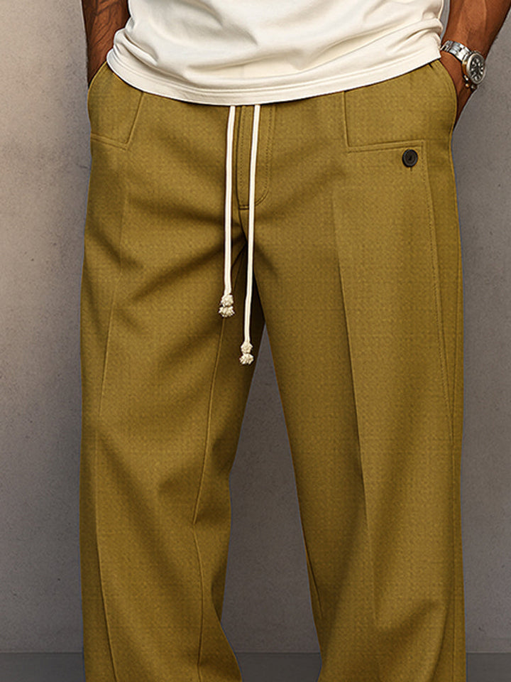 Gros plan sur la taille du pantalon vert olive : cordon blanc aux extrémités nouées, poches avant et bouton. 7