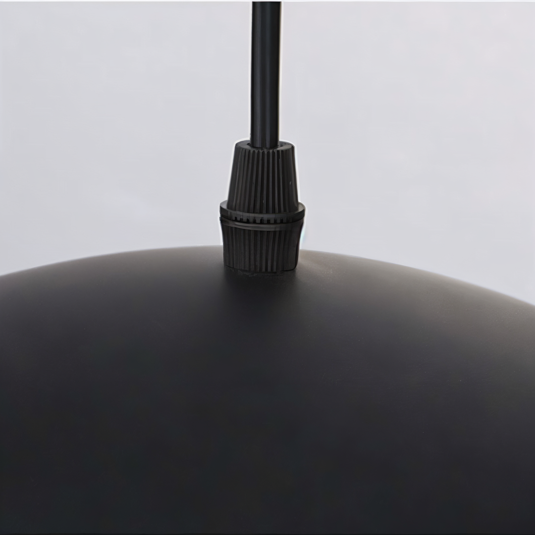 Gros plan sur le serre-cГўble nervurГ© noir et le cordon d'alimentation fixГ©s sur le dessus bombГ© noir de la suspension. 14