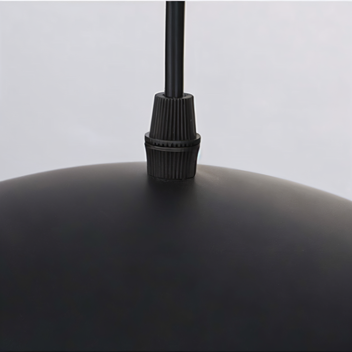 Gros plan sur le serre-cГўble nervurГ© noir et le cordon d'alimentation fixГ©s sur le dessus bombГ© noir de la suspension. 14