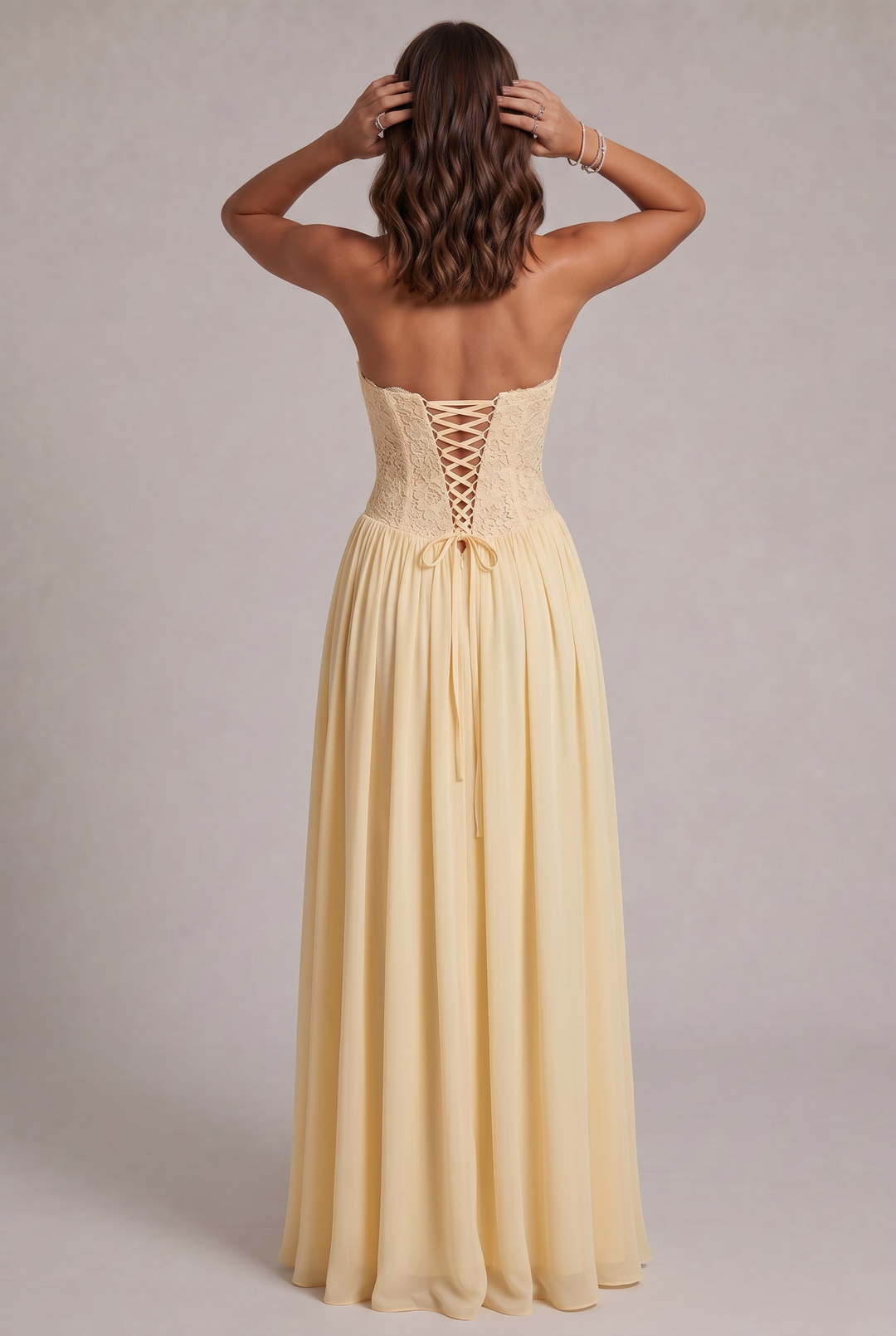 Vue de dos de la robe jaune pâle: laçage croisé du corsage, ruban noué et jupe longue en mousseline. 8