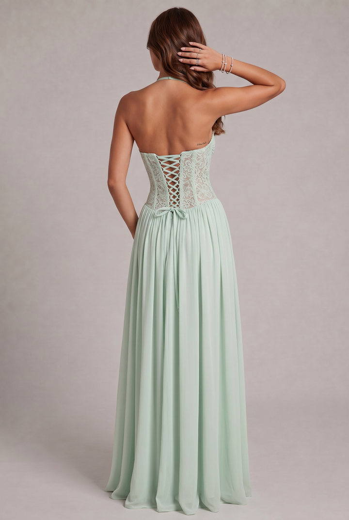 Vue de dos de la robe vert menthe: corsage en dentelle avec laçage croisé, ruban noué à la taille, bijoux au poignet. 11