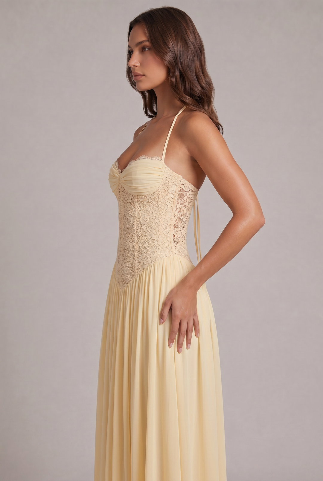 Vue de profil de la robe jaune pâle, avec corsage en dentelle ajourée sur le côté et jupe plissée à la taille. 7