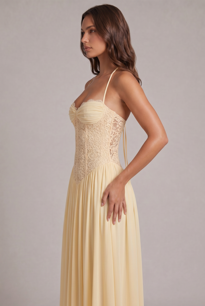 Vue de profil de la robe jaune pâle, avec corsage en dentelle ajourée sur le côté et jupe plissée à la taille. 7