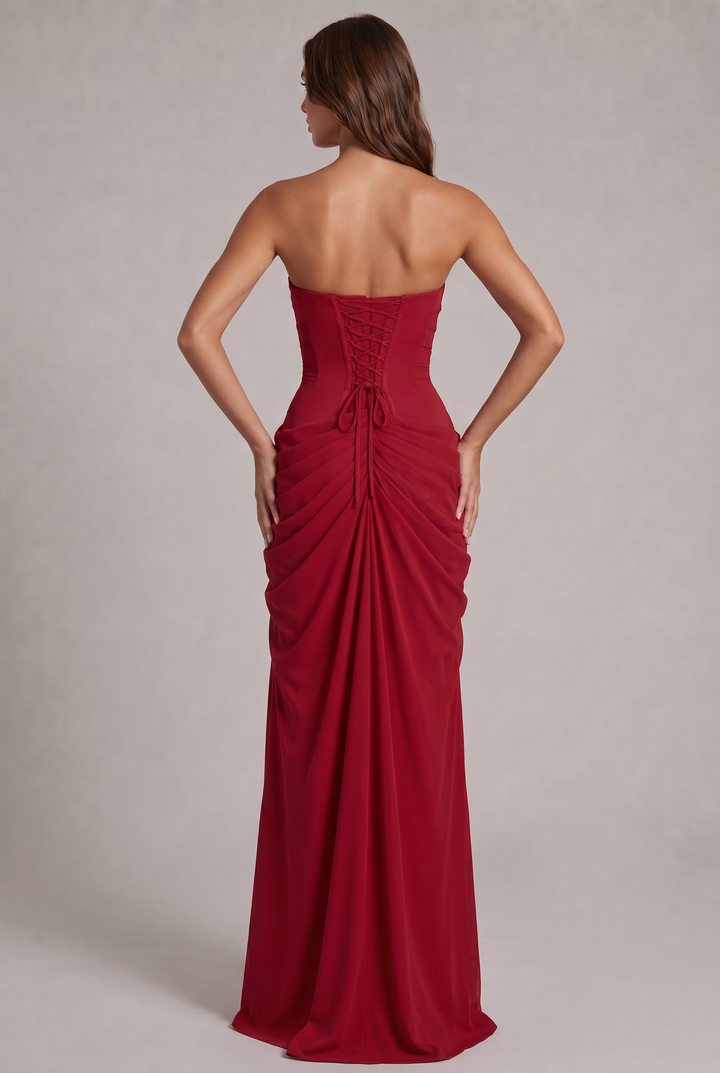 Dos de la robe rouge avec laçage de corset, cordons noués et jupe froncée tombant en longue traîne 24