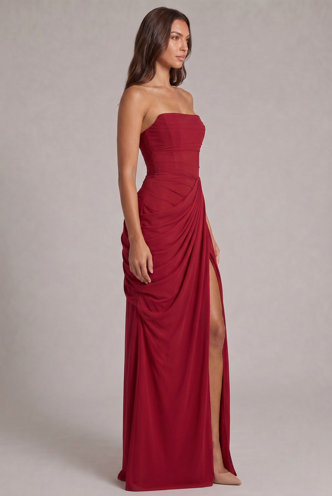 Robe rouge vue de trois quarts, corsage ajusté, drapé sur le côté et fente haute sur la jambe 23