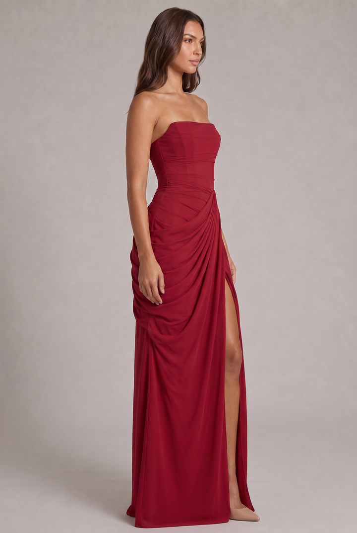 Robe rouge vue de trois quarts, corsage ajusté, drapé sur le côté et fente haute sur la jambe 23