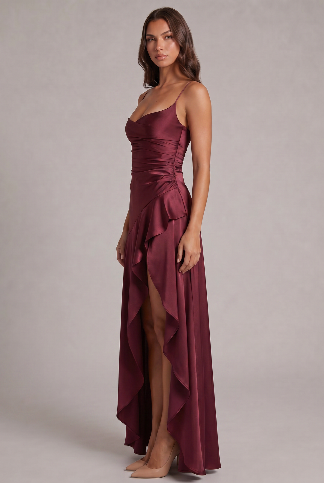 Robe bordeaux en satin vue de trois quarts, montrant le drapé froncé sur le côté de la taille et le volant asymétrique. 3