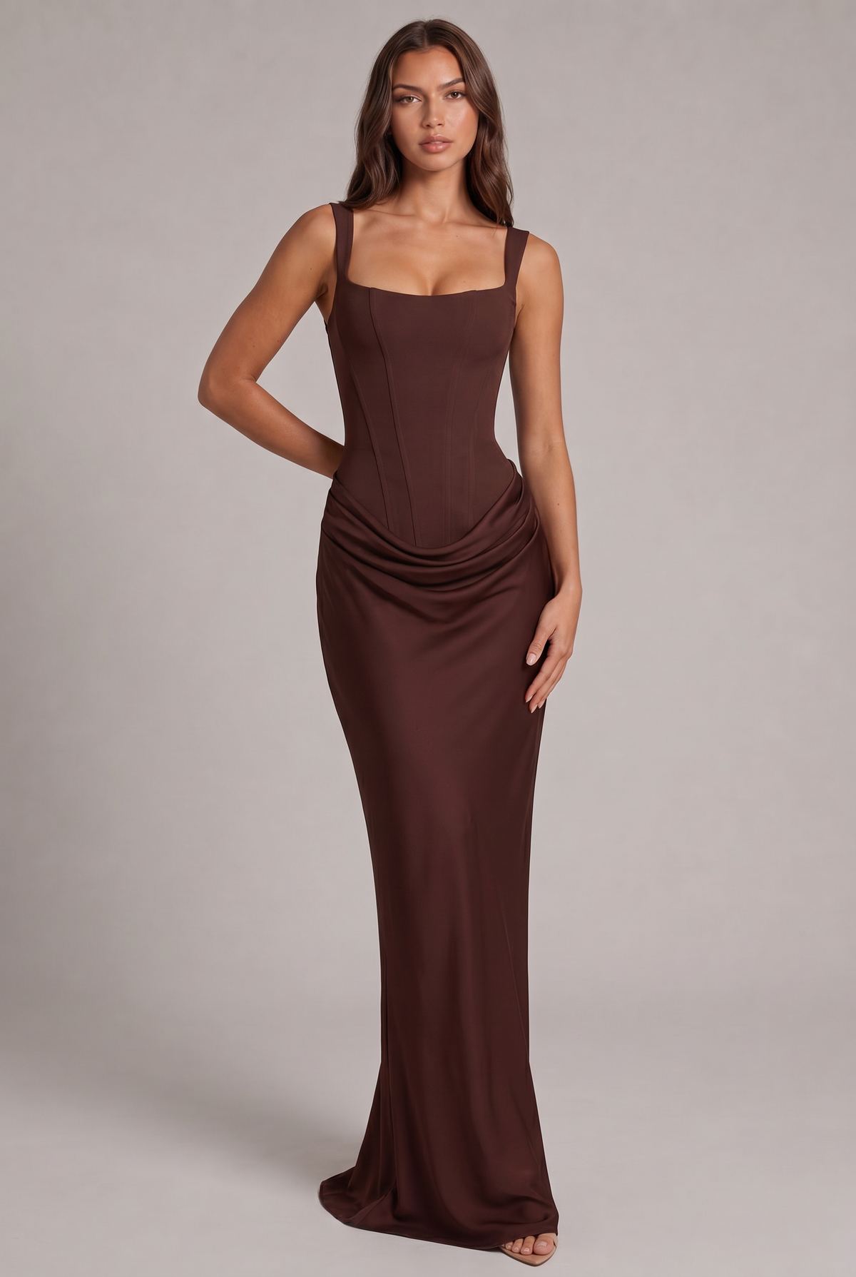 Robe longue marron chocolat portée de face par un mannequin, corsage structuré à baleines, encolure carrée et drapé à la taille. 1