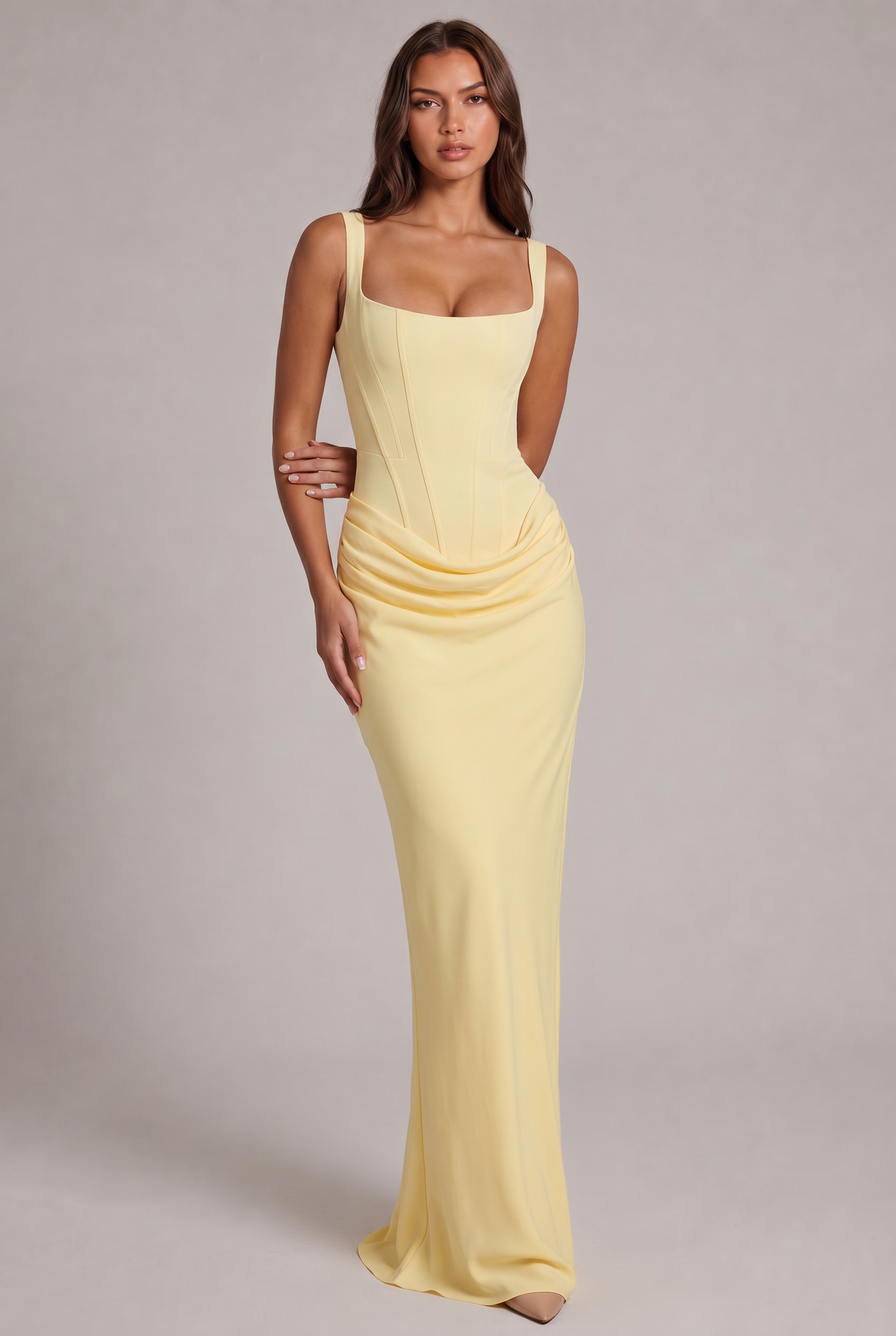 Robe longue jaune pâle portée de face en pied, corsage structuré à encolure carrée et drapé sur les hanches. 21