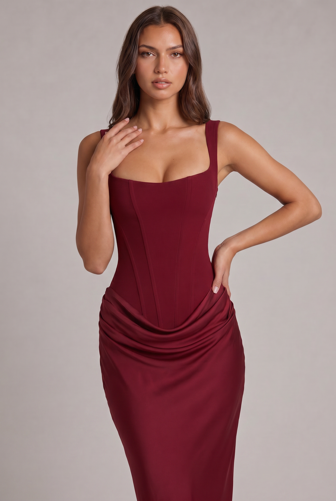Plan rapproché de la robe bordeaux, corsage à coutures verticales, larges bretelles et drapé de la jupe. 18