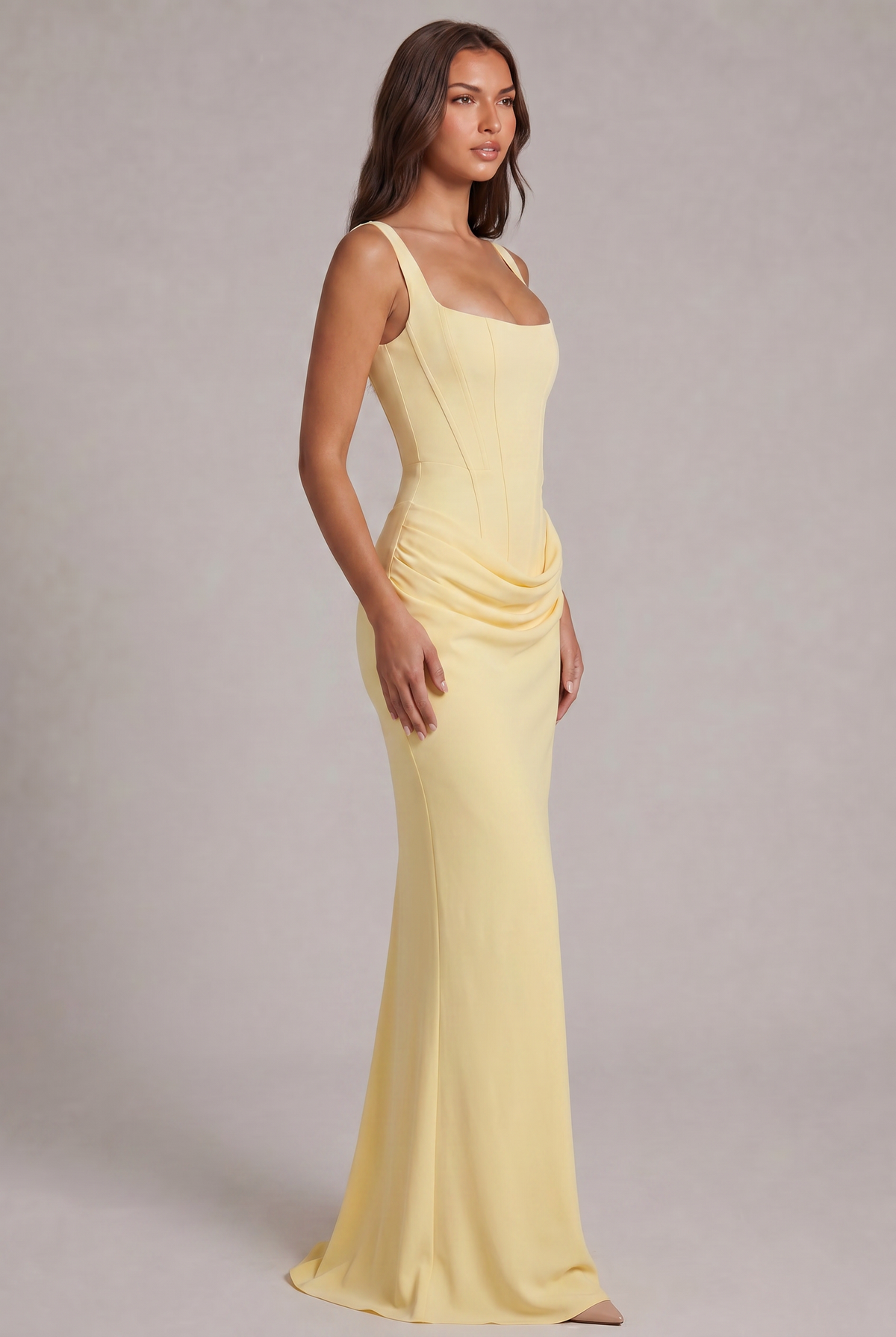 Robe jaune pâle vue de trois quarts, silhouette longue ajustée avec drapé latéral à la taille et traîne légère. 23