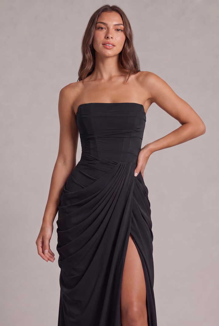 Gros plan sur le buste de la robe noire, corsage structuré, drapé plissé et fente sur la jambe 26