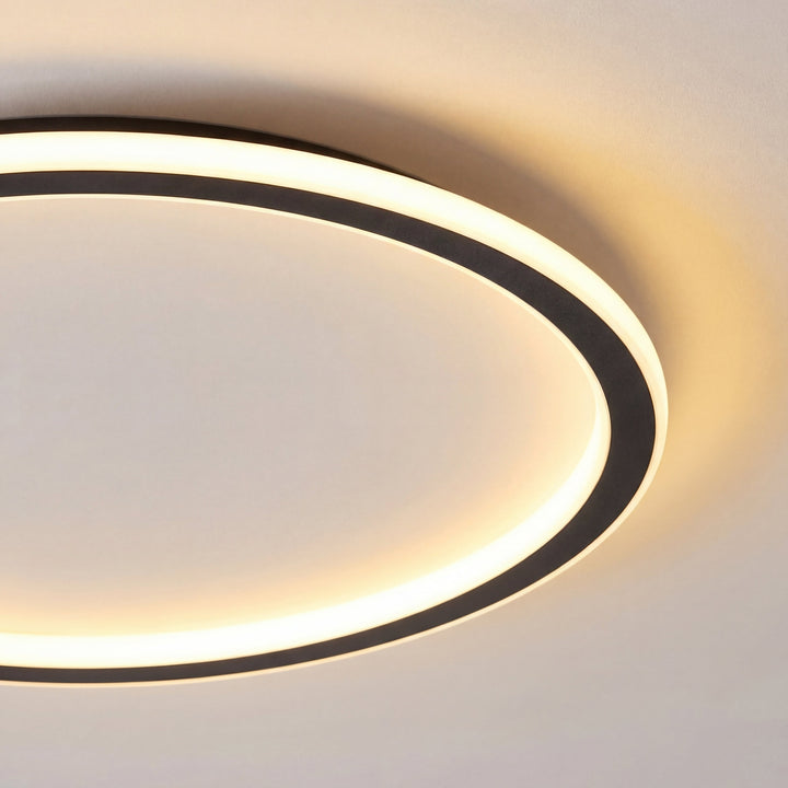 Gros plan sur le bord de l'anneau noir et sur le diffuseur lumineux blanc chaud, avec le halo sur le plafond. 2