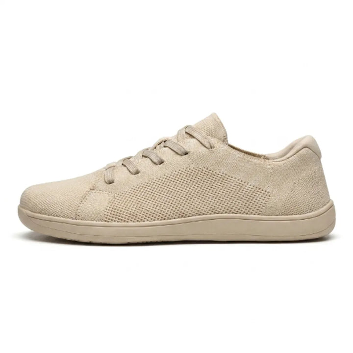 Vue de profil d'une basket beige en maille tricotée aérée, avec lacets plats et semelle fine assortie, sur fond blanc. 1
