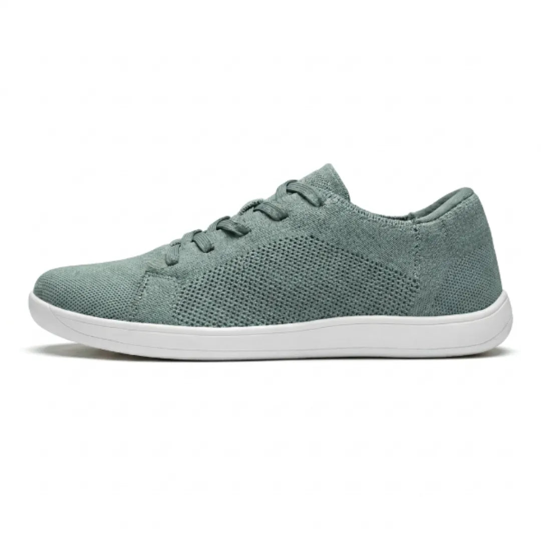 Profil d'une basket en mesh vert sauge à lacets et semelle blanche, sur fond blanc. 28