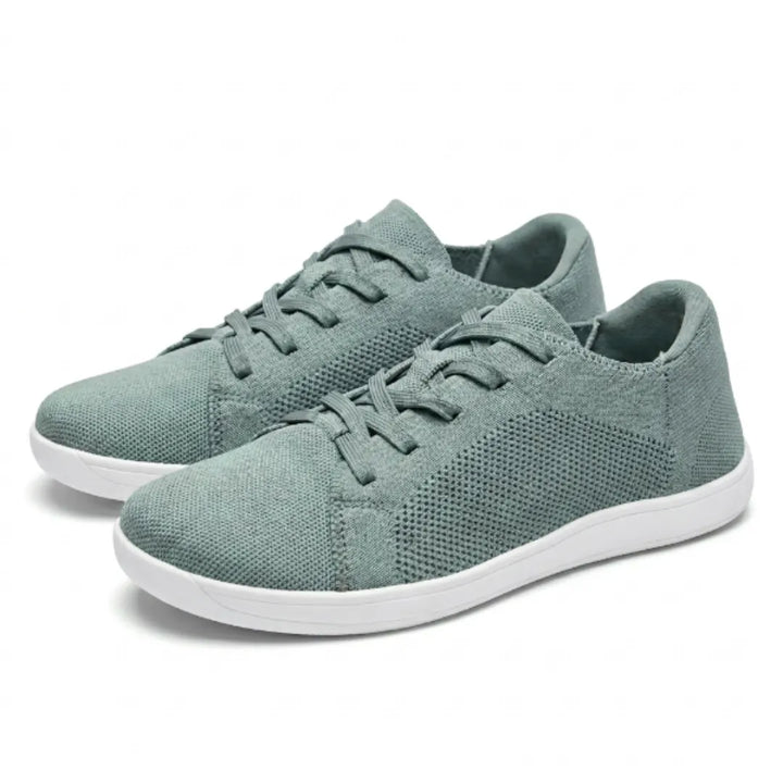 Paire de baskets en mesh vert sauge à lacets et semelle blanche, vue de trois quarts sur fond blanc. 34
