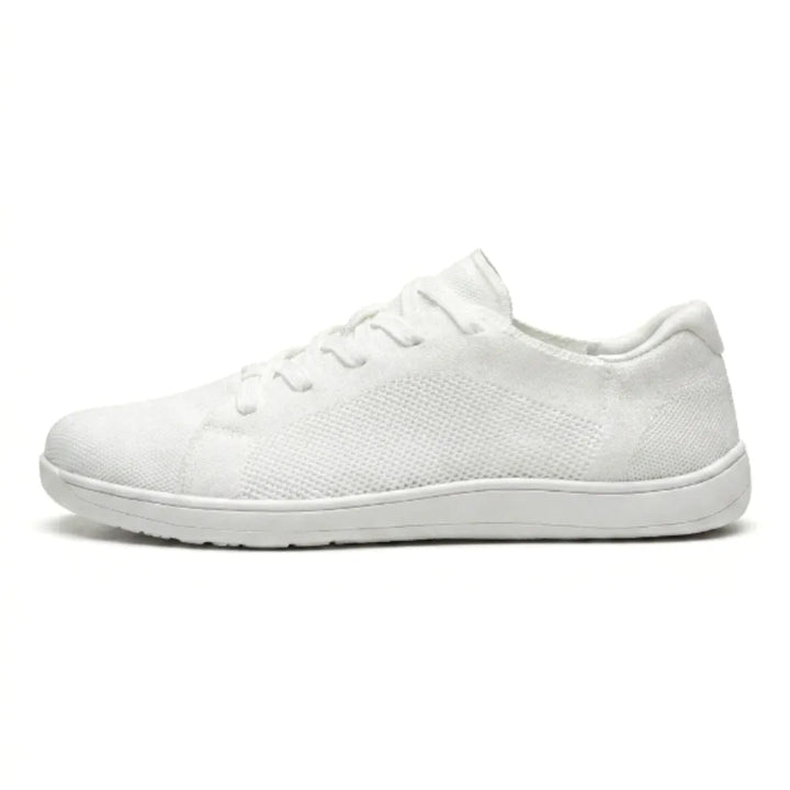 Profil d'une basket blanche en mesh à lacets et semelle blanche, sur fond blanc. 37