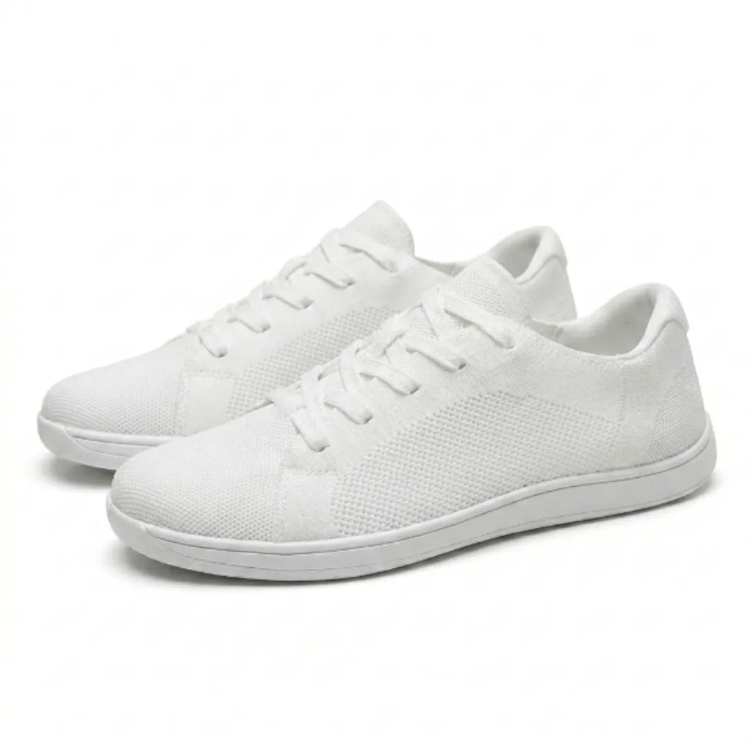 Paire de baskets basses blanches en mesh tricoté à lacets, vue de trois quarts sur fond clair, semelle fine et plate. 43