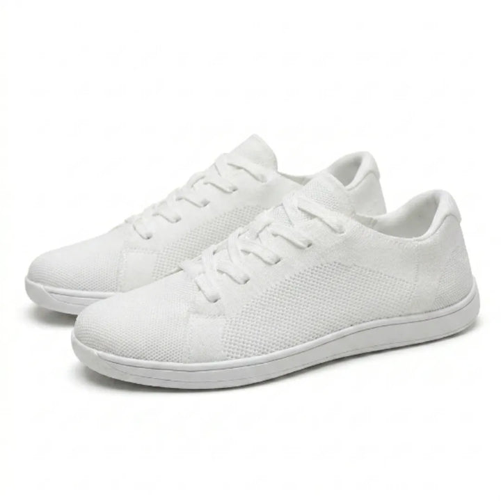 Paire de baskets basses blanches en mesh tricoté à lacets, vue de trois quarts sur fond clair, semelle fine et plate. 43