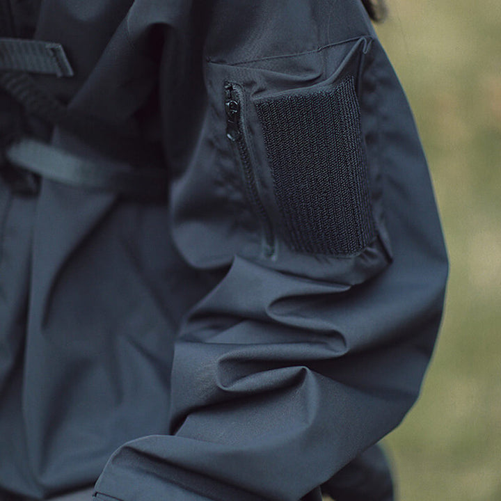 Détail de la manche de la veste noire avec poche zippée et bande de fermeture à scratch. 6